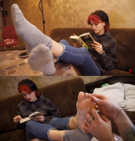 Bad naughty Red Hair girl reads a book while her pretty feet get tickled